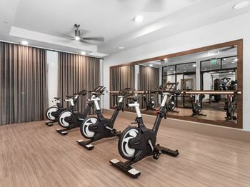 a gym with a row of exercise bikes in it